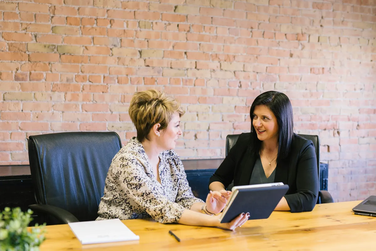 Two women talking about loan vs. mortgage
